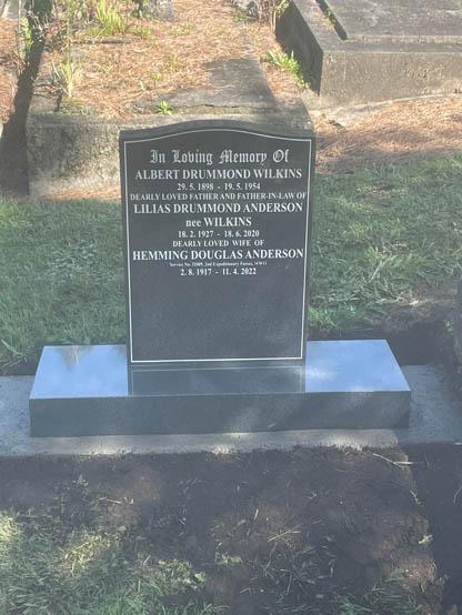 Classic upright headstone with low saddle top, crafted from polished granite. This tall companion headstone has the details of three people and leaves space for more.  By Mark Memorials in Levin, New Zealand.