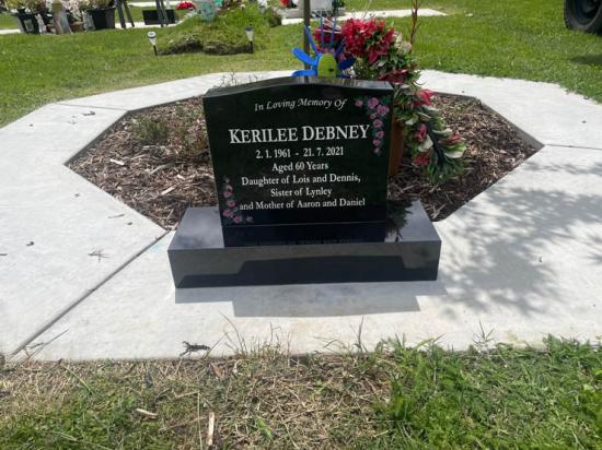 Classic upright headstone with low saddle top and flower engravings, crafted from polished granite by Mark Memorials in Levin, New Zealand.