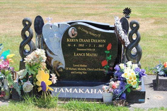 Custom upright headstone with carved koru and a carved angel, crafted from polished granite by Mark Memorials in Levin, New Zealand