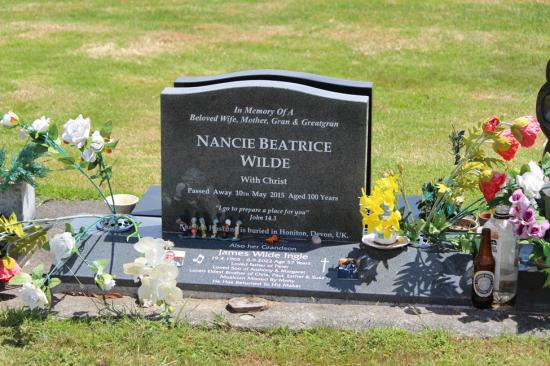 Classic upright headstone with low saddle top, crafted from polished granite. A companion inscription is done on the base.  By Mark Memorials in Levin, New Zealand.