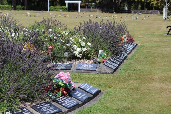 Black granite cremation plaques mounted around a garden