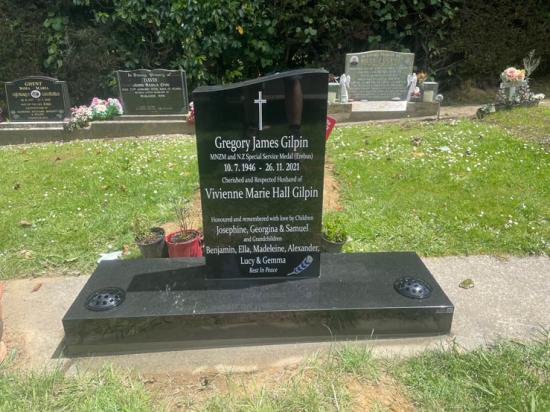 Contemporary upright tall headstone with half saddle top, companion headstone leaving space for date, crafted from polished granite by Mark Memorials in Levin, New Zealand.
