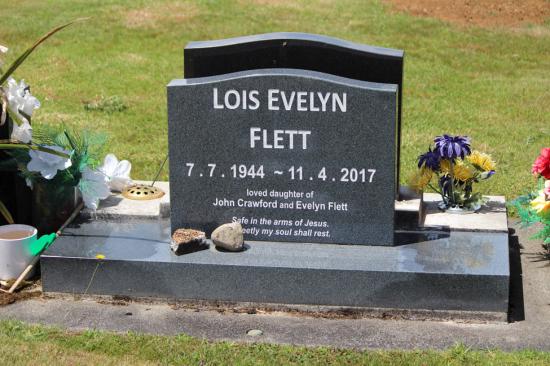 Contemporary upright headstone for a single person with low saddle top, crafted from grey polished granite